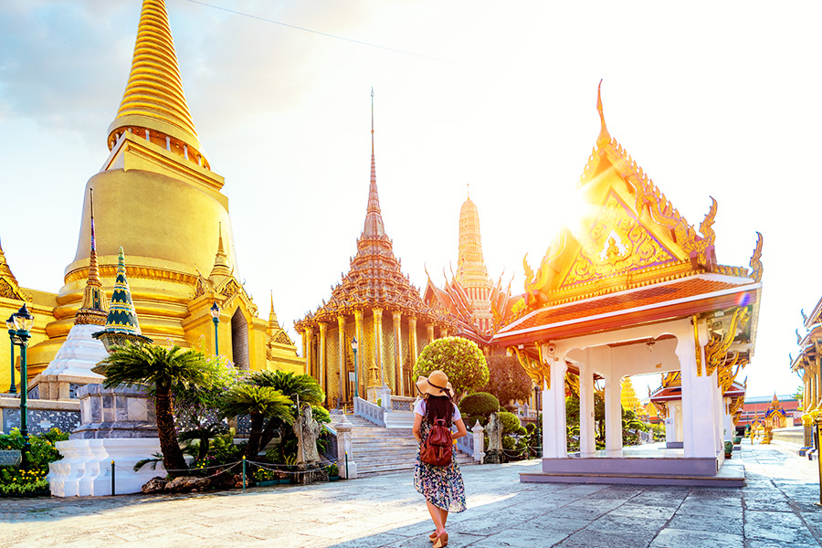 Wanita sedang liburan di bangkok dan berfoto di depan Grand Palace