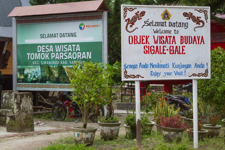 Signposts in Tomok village, and billboards for the Sigale-gale tourist attraction on the island of Samosir.