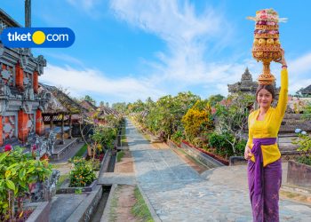 balinese woman in front of village
