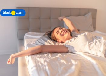 woman wakes up in bed happy